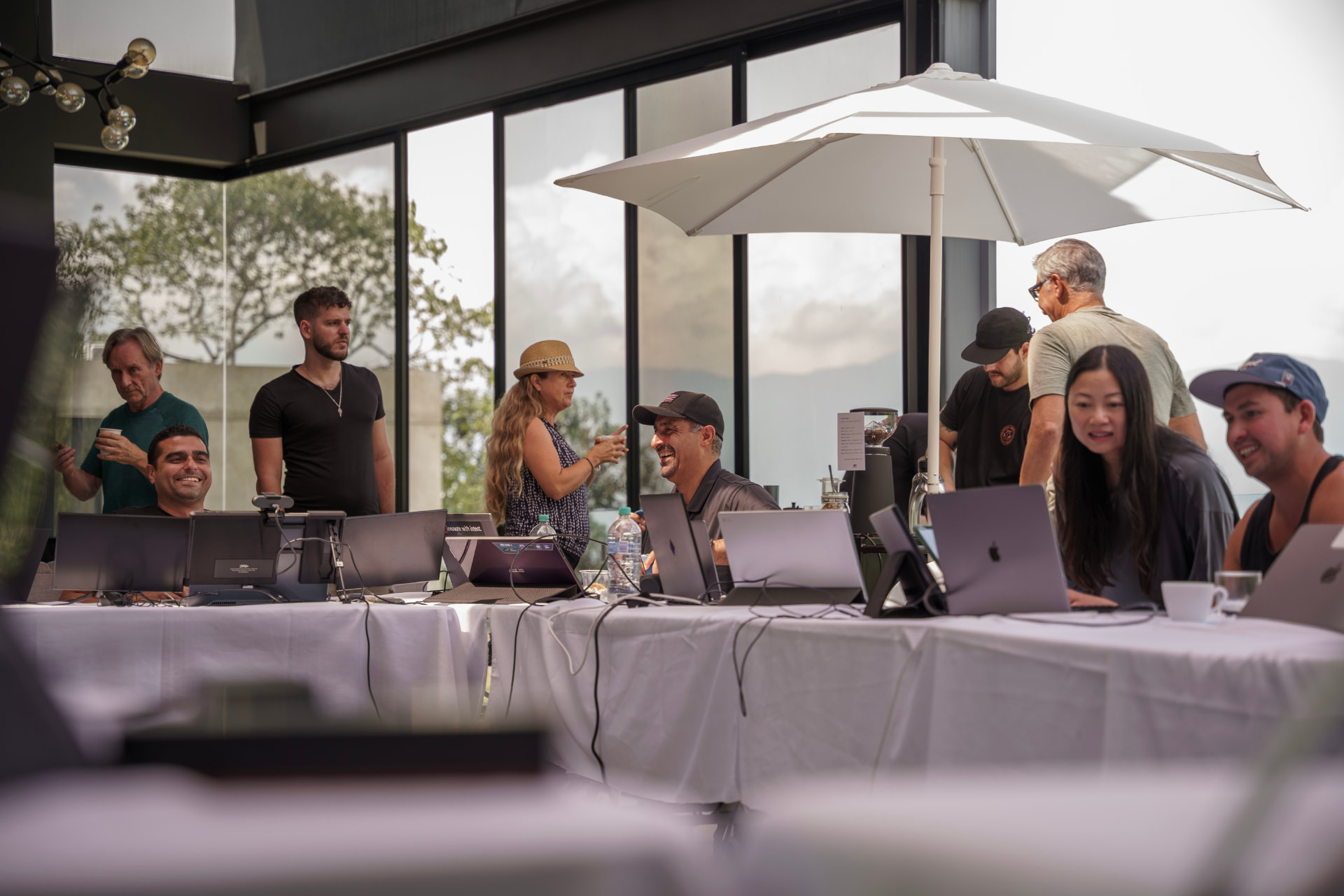 Team members working from a terrace with laptops during the trading week